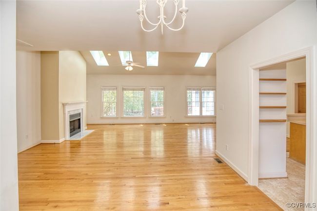 Unfurnished living room featuring a healthy amount of sunlight, light wood finished floors, and a fireplace | Image 5