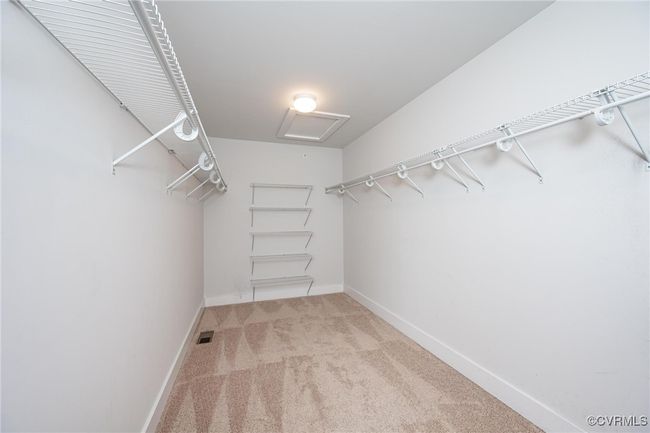 Spacious closet with carpet and attic access | Image 15