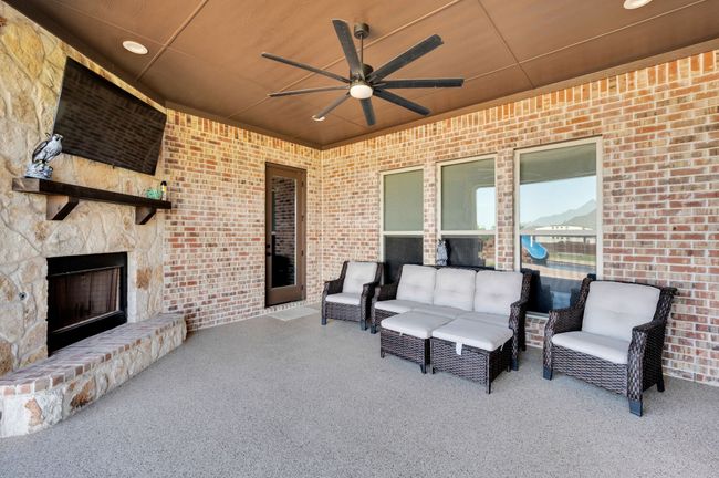 View of patio featuring a ceiling fan and an outdoor living space with a fireplace | Image 5