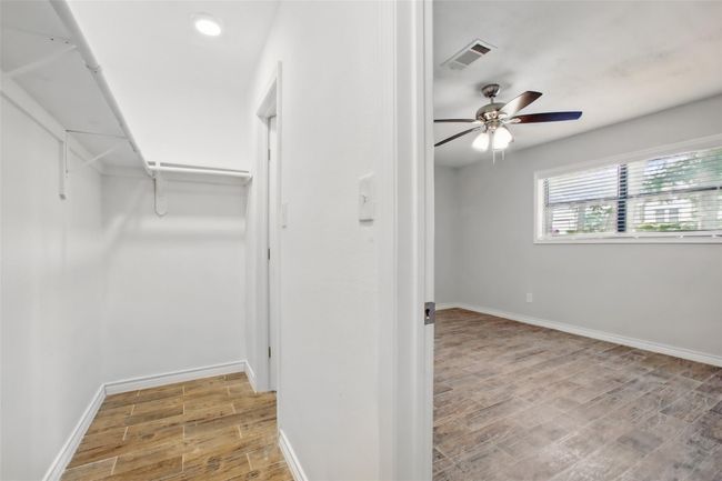The ideal balance of comfort and privacy, this primary bedroom offers a spacious walk-in closet with shelving and abundant hanging space. | Image 21