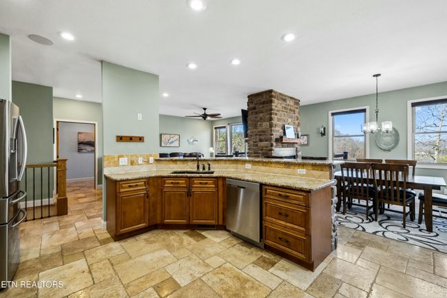 Warm wood cabinetry with low maintenance beautiful tile flooring. | Image 14
