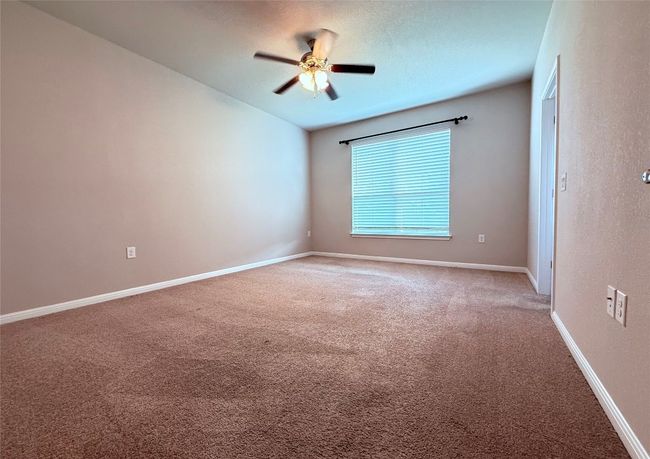 Unfurnished room featuring light carpet, ceiling fan, and baseboards | Image 7
