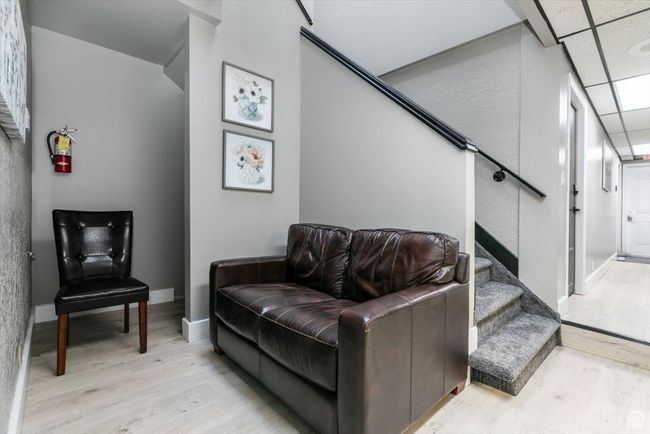 Living area with light wood finished floors, stairs, and a textured wall | Image 8