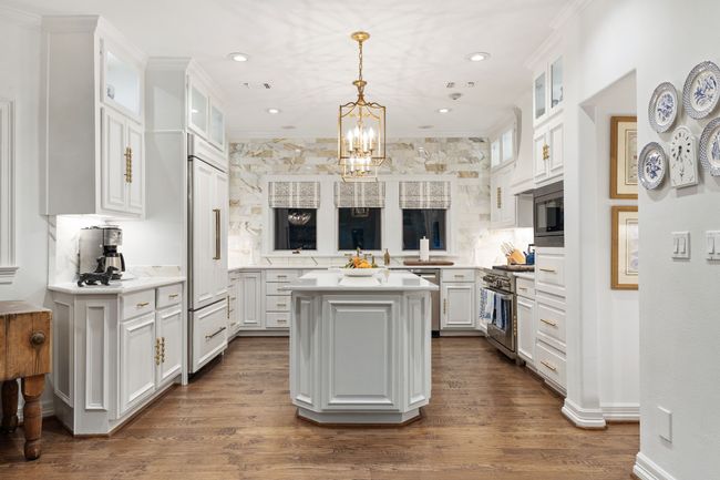 Modern kitchen with marble, Quartz counters, hardwood floors, and beautiful gold-finished light fixture | Image 14