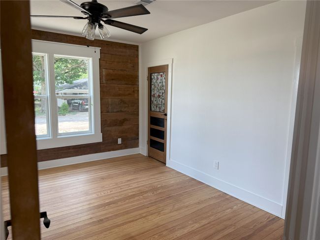 Spare room with light wood-style flooring, ceiling fan, and wood walls | Image 31