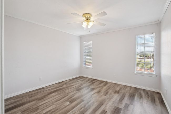 Spare room with crown molding, light wood finished floors, and ceiling fan | Image 8