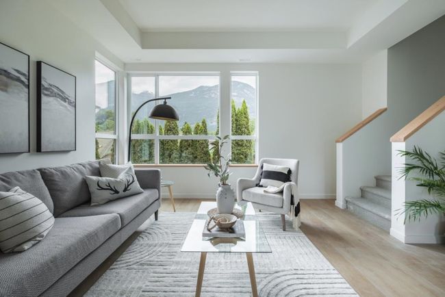 Living room featuring light wood-style floors, stairs, and a tray ceiling | Image 11