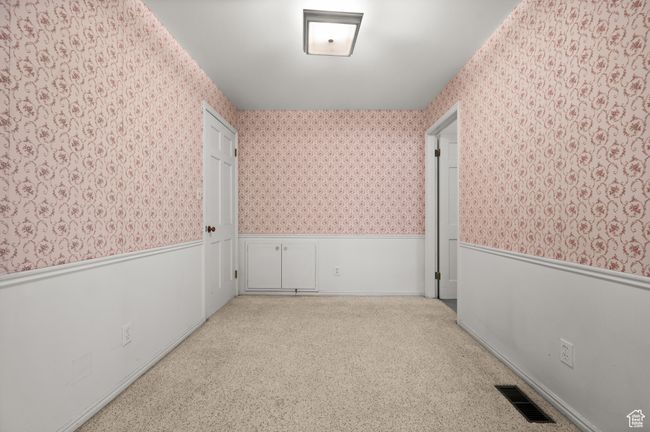 Carpeted empty room featuring wallpapered walls and a wainscoted wall | Image 16