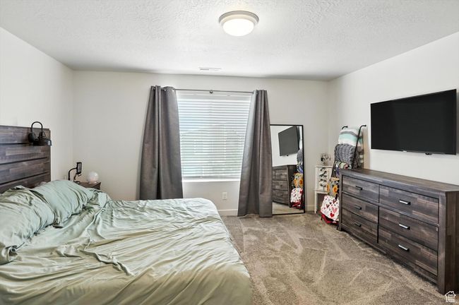 Primary Bedroom featuring light carpet and a textured ceiling | Image 35