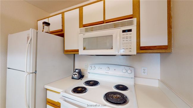 Kitchen with white cabinets and white appliances | Image 9