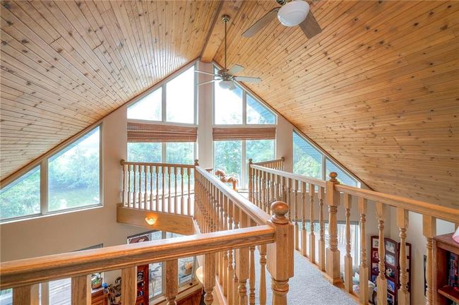 Hall featuring wood ceiling, plenty of natural light, high vaulted ceiling, an upstairs landing, and carpet | Image 23