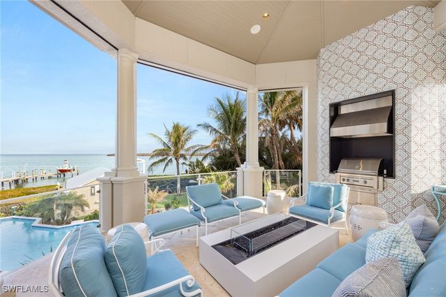 Covered back patio with built in grill, custom tile, fire table, remote controlled screens and Bay views | Image 21