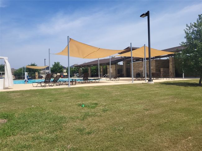 View of home's community featuring a pool, a lawn, and a patio area | Image 12