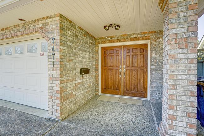 Property entrance with a garage and brick siding | Image 15