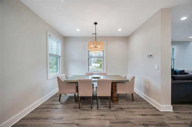 Dining space featuring baseboards, wood finished floors, recessed lighting, and a notable chandelier | Image 16