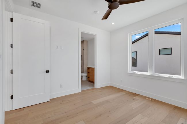 Unfurnished bedroom featuring light wood-style floors, ensuite bathroom, recessed lighting, and ceiling fan | Image 34