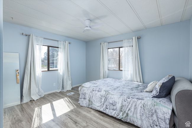 Bedroom featuring visible vents, baseboards, a ceiling fan, and wood finished floors | Image 11