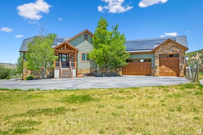 View of front of property featuring a garage, solar panels, and a front yard | Image 2