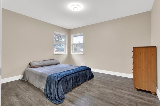 Bedroom with baseboards and wood finished floors | Image 23