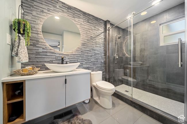 Full bathroom featuring toilet, tile patterned floors, vanity, and a shower stall | Image 11