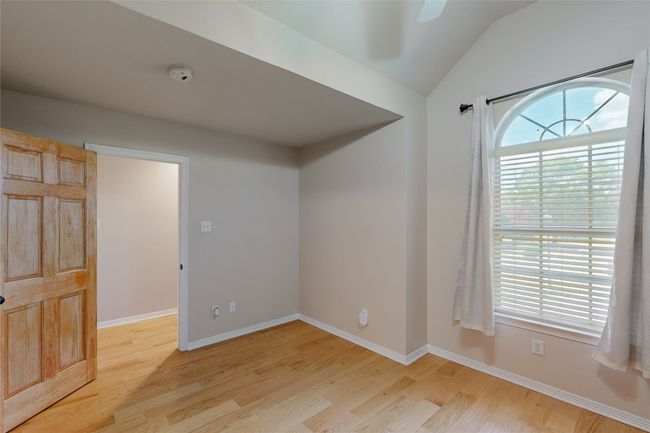 Unfurnished room with light wood finished floors, vaulted ceiling, baseboards, and ceiling fan | Image 25