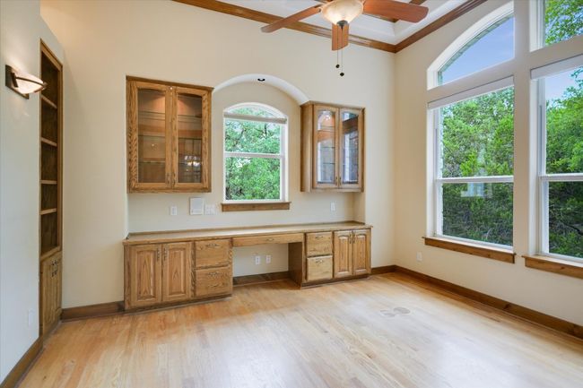 Natural lighting, soft arches, wood flooring, warm wood tones for the display and bookshelves. Lighting is recessed, sconce, natural or by fan. There is also electric shades to cover the windows...in case you're distracted by the outside beauty of the seasons. A very productive setting, for sure! | Image 6