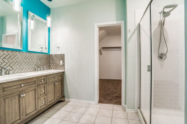 Bathroom with a stall shower, a spacious closet, double vanity, and decorative backsplash | Image 8