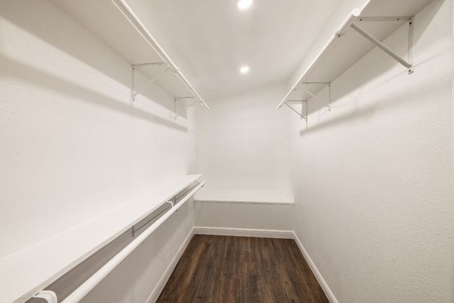Walk in closet featuring dark wood-style flooring | Image 17