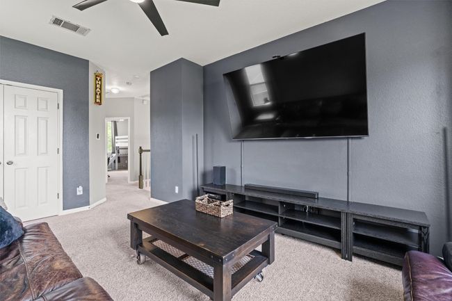 Carpeted living room with a ceiling fan, baseboards, and a textured​​‌​​​​‌​​‌‌​‌‌​​​‌‌​​‌‌​‌​​​​​‌ wall | Image 22
