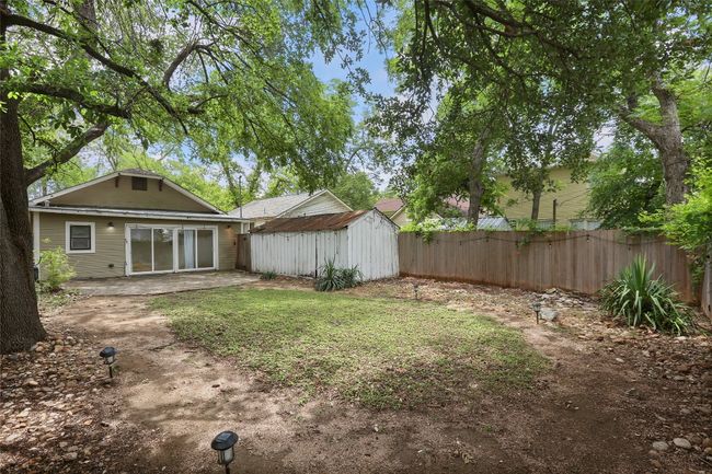 View of yard featuring a storage unit and a patio | Image 25