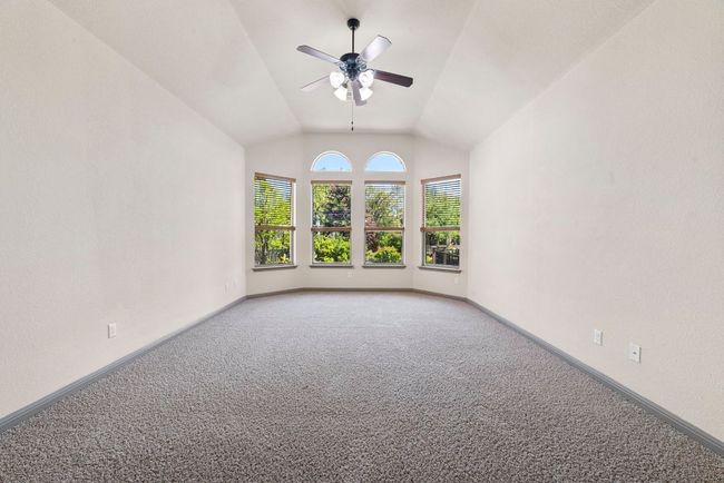 Carpeted spare room with ceiling fan and lofted ceiling | Image 20