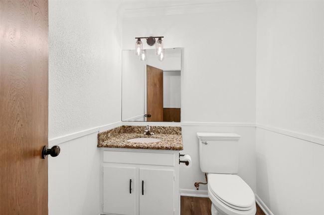 Half bathroom with vanity, toilet, wainscoting, and wood finished floors | Image 21