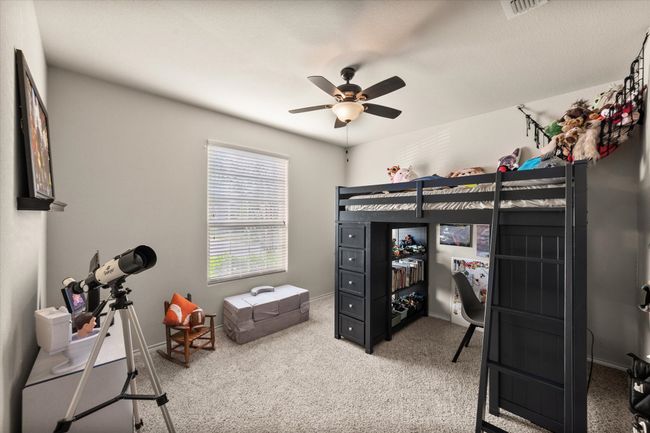 Bedroom featuring visible vents, baseboards, a ceiling fan, and light carpet | Image 29