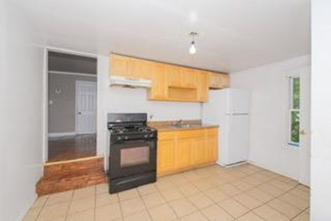 Kitchen featuring gas stove, freestanding refrigerator, under cabinet range hood, and light brown cabinets | Image 32