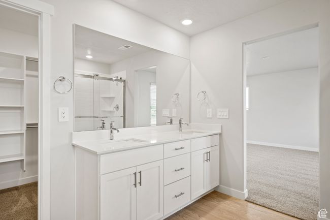 Full bathroom featuring a spacious closet, double vanity, a shower stall, baseboards, and recessed lighting | Image 32