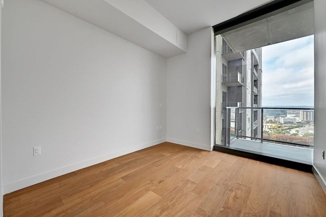 Empty room with baseboards, wood finished floors, and floor to ceiling windows | Image 10