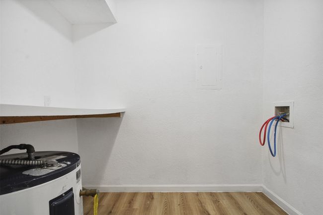 Spacious closet featuring light wood-style floors, water heater, and electric panel | Image 8