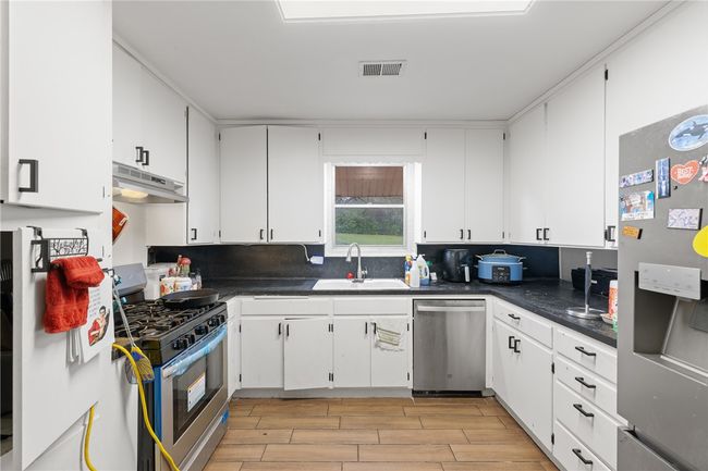 Kitchen featuring white cabinets, sink, and appliances with stainless steel finishes | Image 10