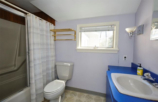 Full bathroom featuring shower / bath combination with curtain, toilet, a healthy amount of sunlight, and vanity | Image 19