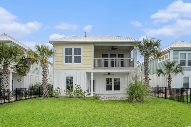 Rear view of house with ceiling fan, board and batten siding, and a balcony | Image 30
