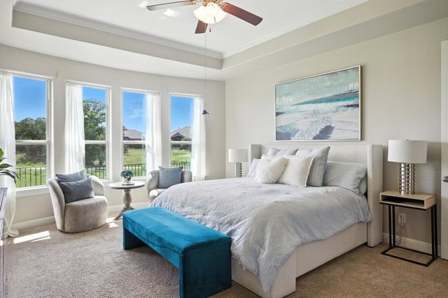 Carpeted bedroom featuring ornamental molding, a tray ceiling, and a ceiling fan | Image 16
