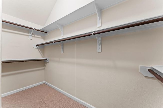 The spacious walk-in closet offers ample room for clothing, shoes, and accessories. Built-in shelving and double hanging rods make it easy to stay organized. | Image 29