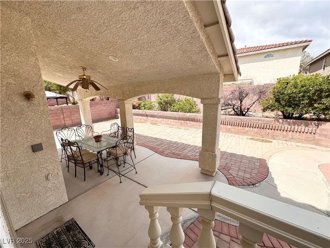 View of patio featuring a fenced backyard, a ceiling fan, and outdoor dining space | Image 29