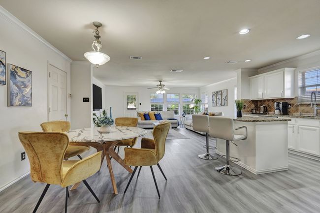 Dining area featuring light wood-type flooring, crown molding, and ceiling fan | Image 10