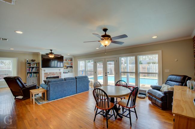 Dining room featuring light wood finished floors, crown molding, french doors, a fireplace, and recessed lighting | Image 11