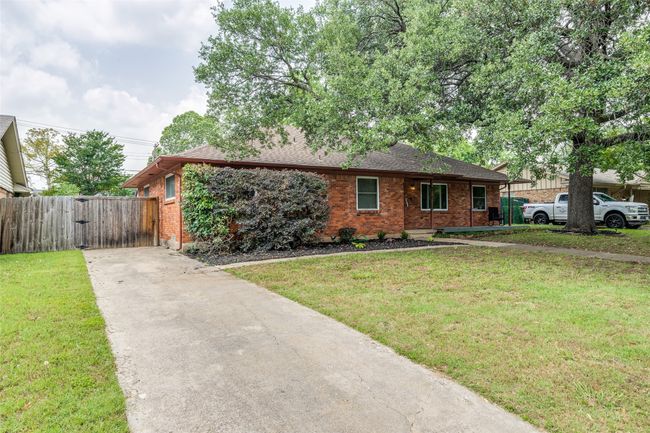 View of front of property with brick siding, driveway, a gate, and a shingled roof | Image 4