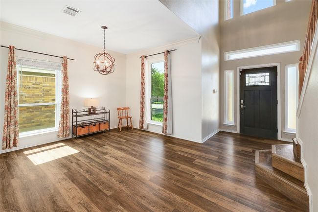 Foyer entrance featuring baseboards, dark wood-style flooring, visible vents, and an inviting chandelier | Image 11