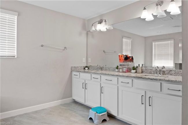 Full bath featuring baseboards, double vanity, visible vents, and a sink | Image 26