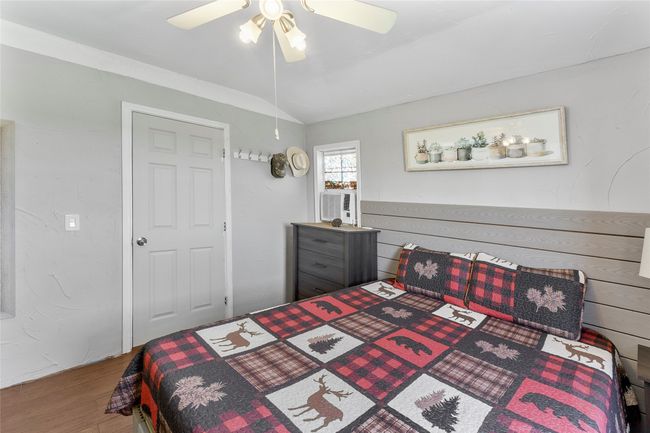 Bedroom featuring ceiling fan, vaulted ceiling, and wood finished floors | Image 13