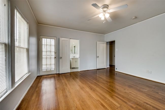 Unfurnished room with wood finished floors, a ceiling fan, crown molding, and a smoke detector | Image 23